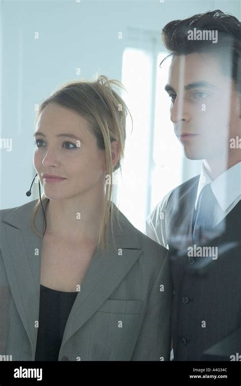 Mr Man And Woman In Business Outfit Stand Behind A Pane And Observe