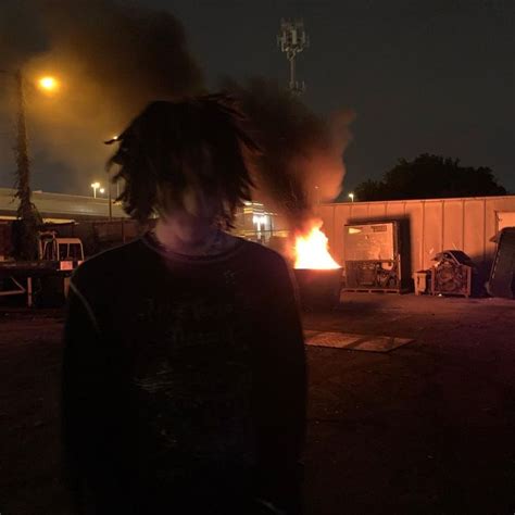 A Man With Dreadlocks Standing In Front Of A Fire