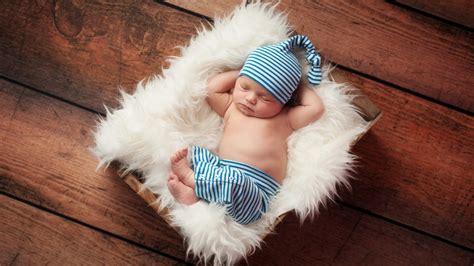 Cute Baby Is Sleeping On White Fur Cloth Wearing White Blue Stripes