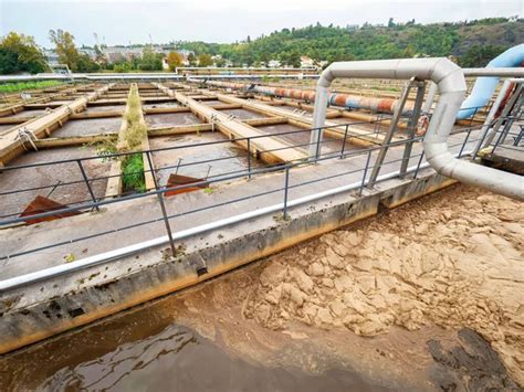 Tubería y puente a pie sobre la piscina de aguas residuales Depósito