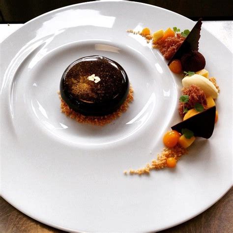 A White Plate Topped With Desserts On Top Of A Wooden Table