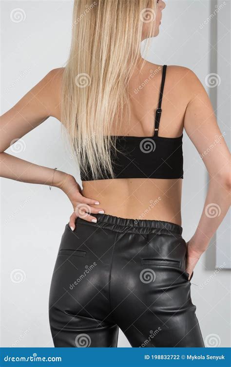 Stijlvolle Jonge Blonde Vrouw In Een Strakke Zwarte Broek Met Een Zwart En Wit Shirt In De Buurt