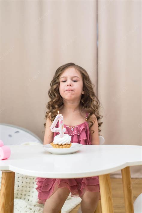 Premium Photo A Girl Blowing Out A Candle On A Birthday Cake