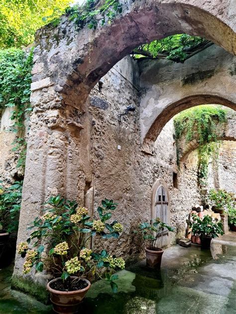 An Arch In The Side Of A Building With Potted Plants