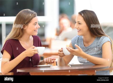 Two Happy Friends Having A Good Conversation Sitting In A Bar Terrace