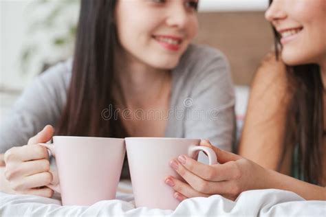 Lesbian Couple In Bedroom At Home Lying Under Blanket One Woman