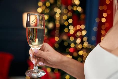 Blonde séduisante femme tenant un verre de champagne acclamant Photo