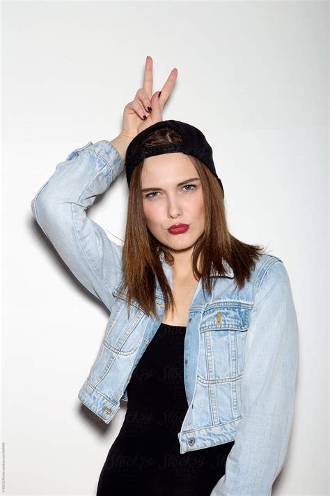 "Woman With Red Lips Showing Peace Sign Over Her Head While Looking At