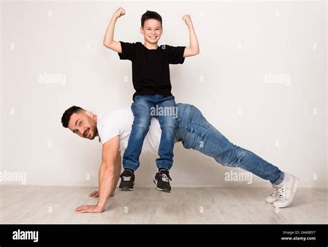 Strong Dad Doing Push Ups With Son On Back Stock Photo Alamy