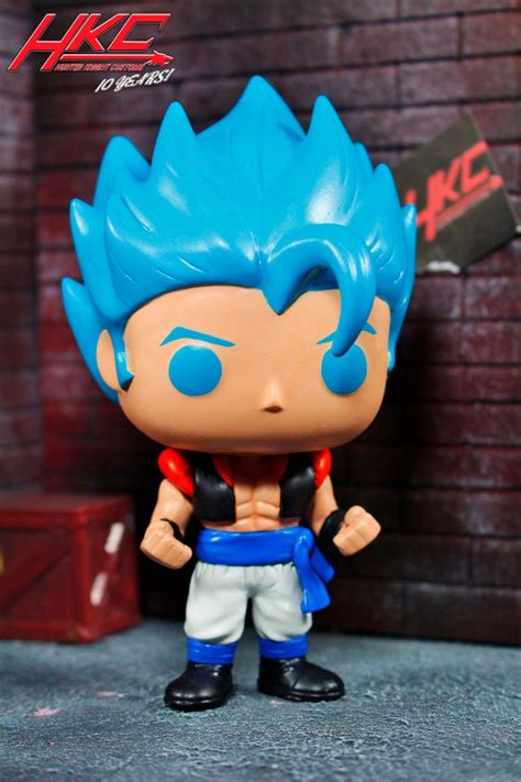 The Action Figure Has Blue Hair And Is Posed In Front Of A Brick Wall