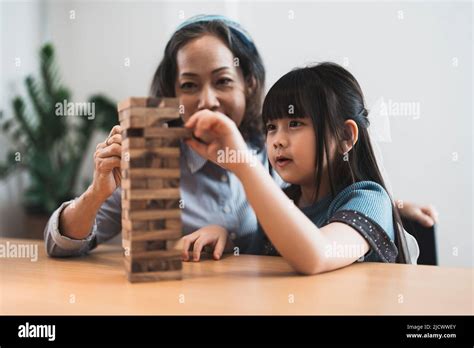 Happy Moments Of Asian Grandmother With Her Granddaughter Playing Jenga