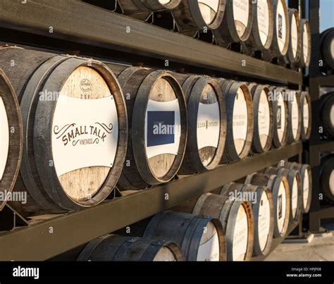 Oak Wine Barrels Stacked On Racks With Names Of Wineries Located In The