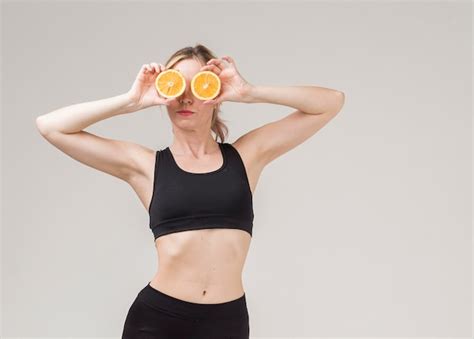 Vista frontal da mulher atlética segurando meias laranja sobre os olhos