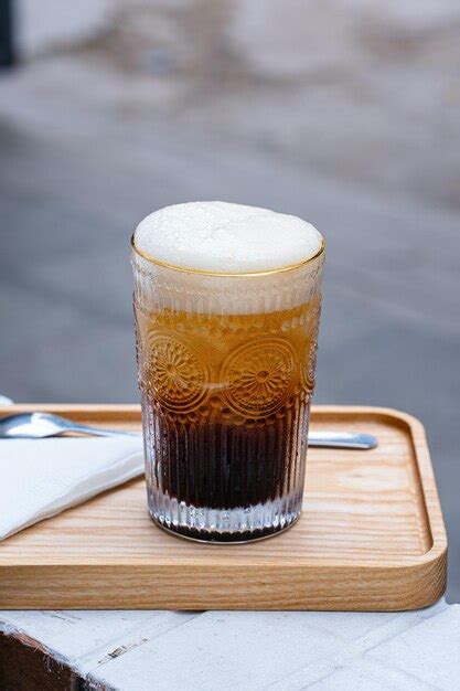 Un Vaso De Cerveza Con Una Espuma Blanca Y Espumosa Foto Premium