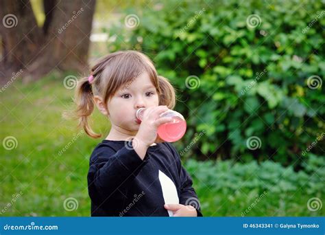 La Petite Fille Boit L Eau D Une Bouteille Sur Le Parc Naturel Image