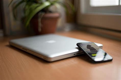 Smartphone Beside Silver Macbook on Brown Wooden Table With Potted ...