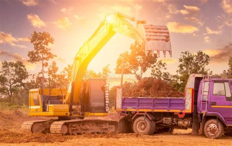 Backhoe Working By Digging Soil At Construction Site And Loading To The