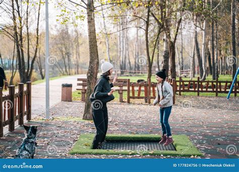 Mom And Her Daughter Jumping Together On Trampoline In Autumn Park