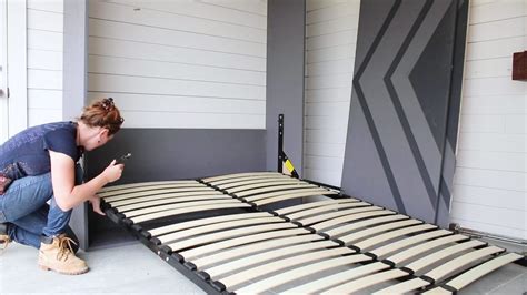 A Woman Kneeling Down To Check Her Cell Phone While Laying On A Bed