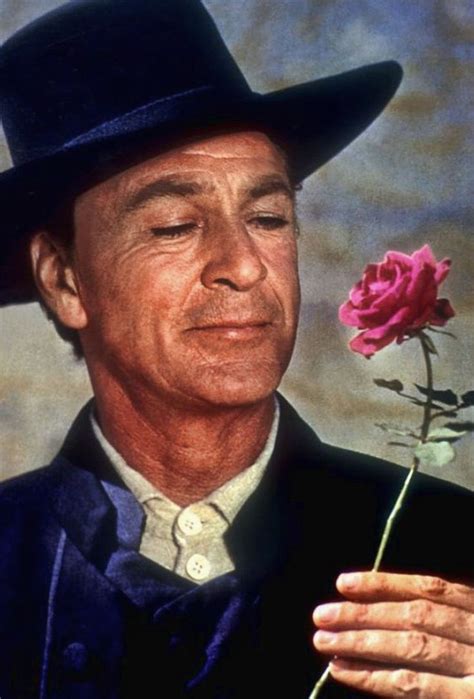 a man in a black hat holding a pink rose