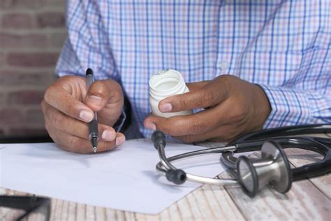 Premium Photo Doctor Writing Documents At Desk In Clinics