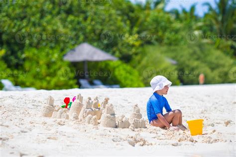 Adorable little girl playing with beach toys during tropical vacation ...