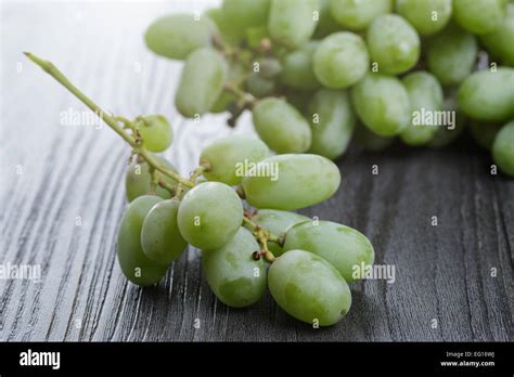 ripe green grapes on black wood table Stock Photo - Alamy