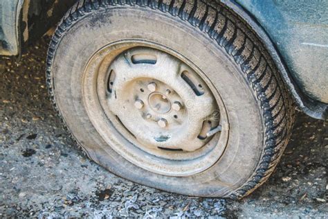 Damaged Flat Tire Of An Old Car On The Road With Selective Focus Stock