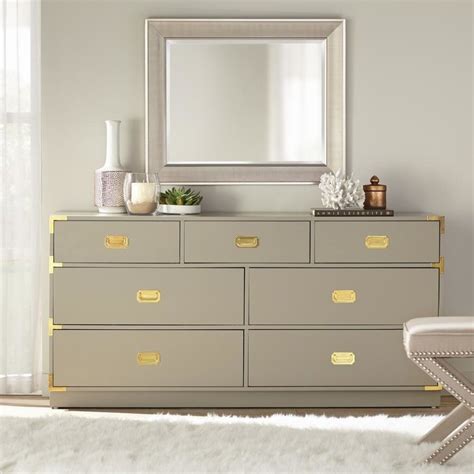 A Seven Drawer Dresser With Gold Hardware At The Corners And Handles