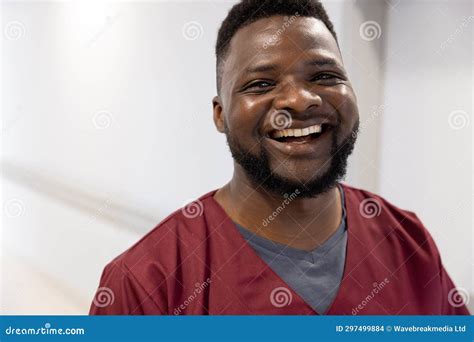 Portrait Of Happy African American Male Doctor In Hospital Corridor