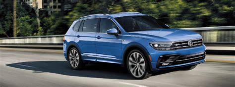 2020 VW Tiguan blue exterior driving to the right on railed road with ...