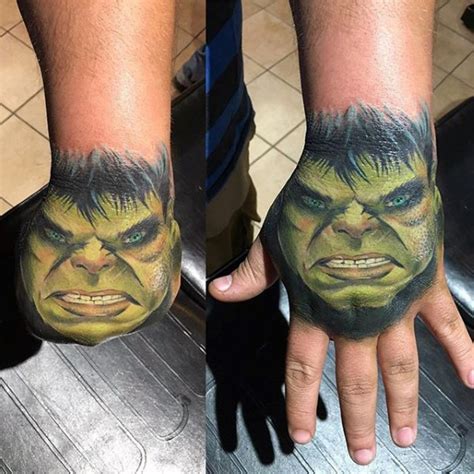 Small colored usual Hulk face tattoo on hand - Tattooimages.biz