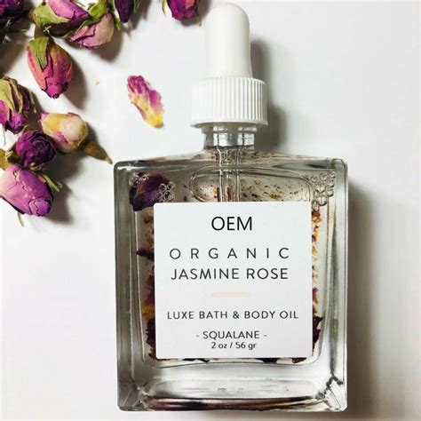 An Open Bottle Of Organic Perfume Next To Flowers