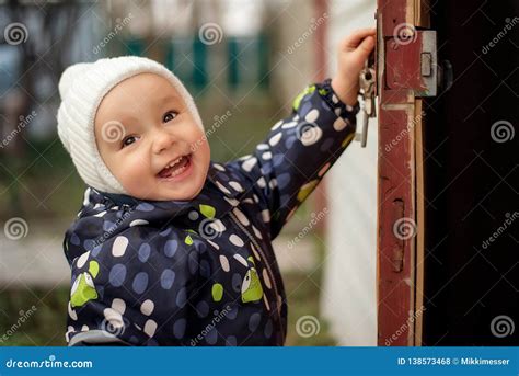 Happy Smiling Toddler in White Woolen Hat Opening Old Door To Somewhere. Children Safety Concept ...