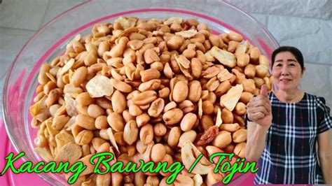 A Woman Standing In Front Of A Bowl Filled With Peanuts