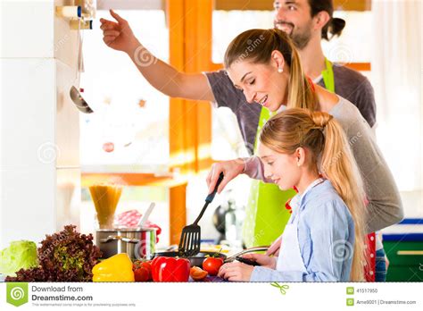 Familia Que Cocina En Comida Sana De La Cocina Nacional Foto De Archivo