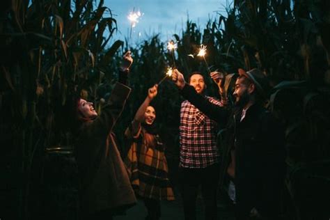 Three People Holding Sparklers In Their Hands While Standing Next To