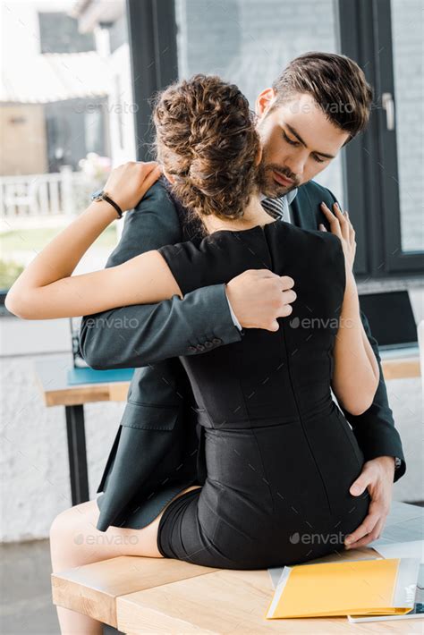 Passionate Businessman Unzipping Dress Of Seductive Businesswoman At