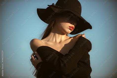 Elegant Woman With Red Lips Elegant Woman With Naked Shoulders In Black Hat On Sunny Blue Sky