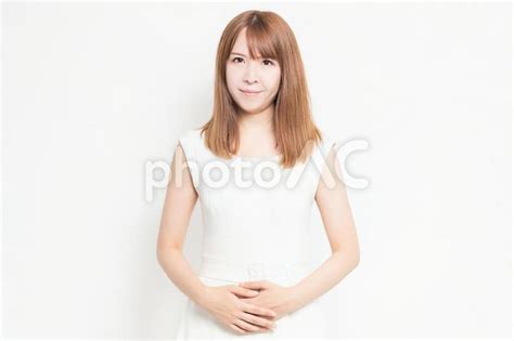 お腹に手を当てる白い服を着た若い女性 No 3719225｜写真素材なら「写真ac」無料（フリー）ダウンロードok