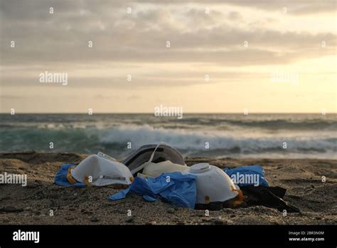 Medical Wastemask And Plastic Gloves Garbage Trash On Sunset Sea Shore