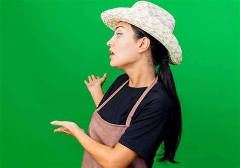 Jardinero De Mujer Hermosa Joven En Delantal Y Sombrero Presentando