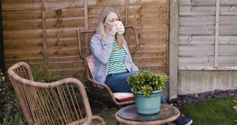 Mature Woman Drinking Coffee And Relax On Patio Porch Or Outdoor Home Garden House Or