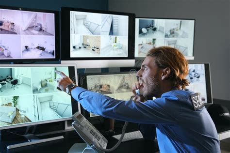 Security Guard Monitoring Modern Cctv Cameras In Surveillance Room