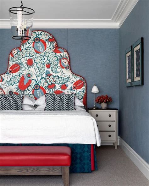 A Bedroom With Blue Walls And White Bedding Has A Red Bench In Front Of It