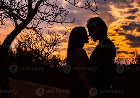 Silhouette of romantic couple in love, man and women in sunset sky