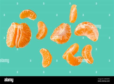 Flying Pieces Of Sweet Peeled Mandarin On Turquoise Background Stock