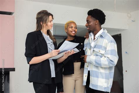 The Blonde Real Estate Agent Attentively Listens To The African Couple S Questions And Concerns