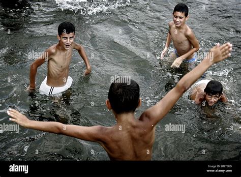 Kosovo Mitrovica Niños jugando en el río Ibar frontera entre los