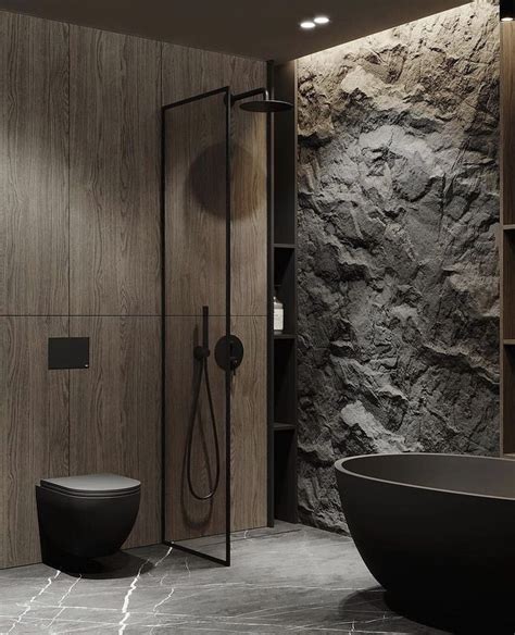 A Black Bathtub Sitting Next To A Stone Wall With A Shower Head In It